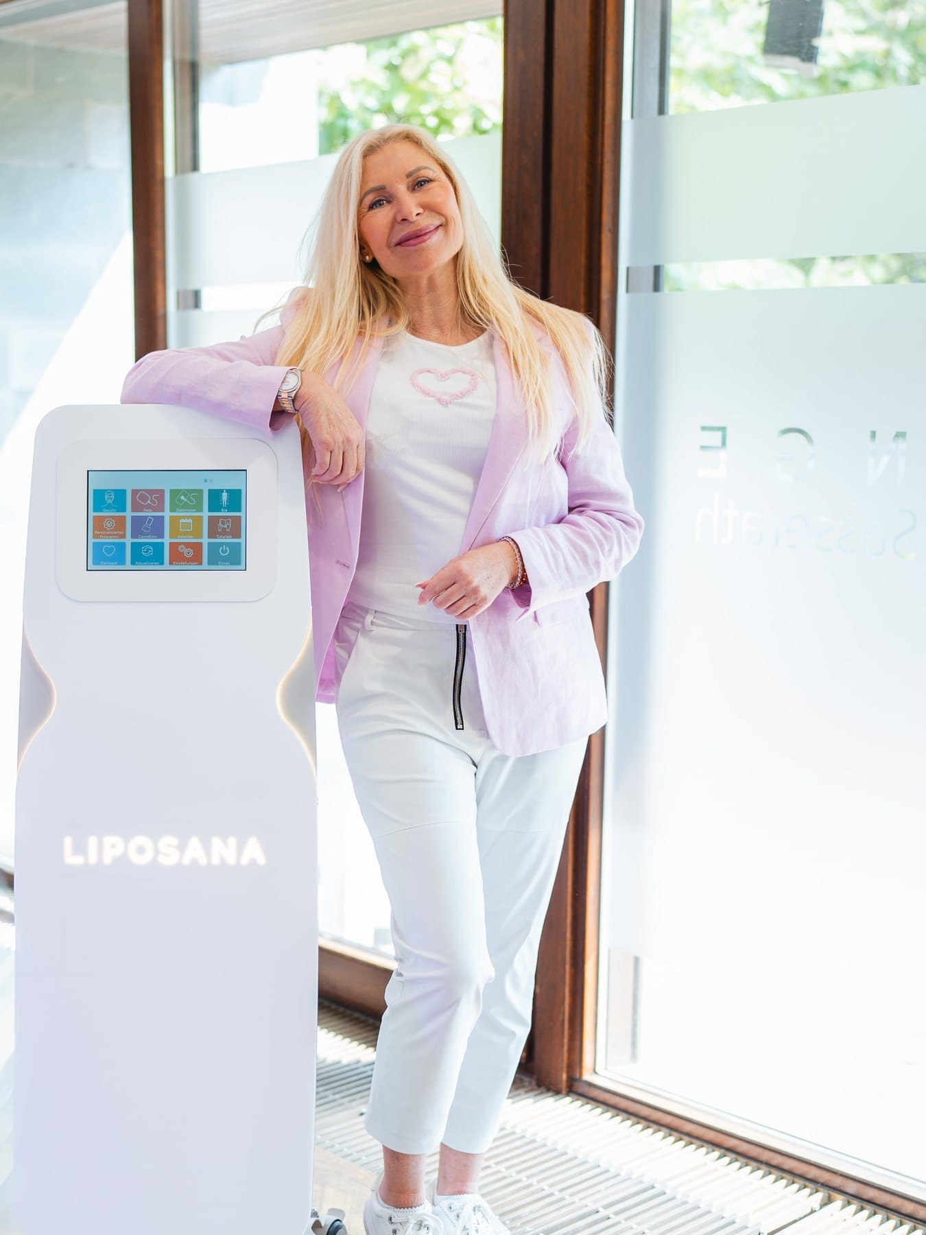 Anja von LIPOSANA3® lehnt lächelnd am LIPOSANA3® NEO System