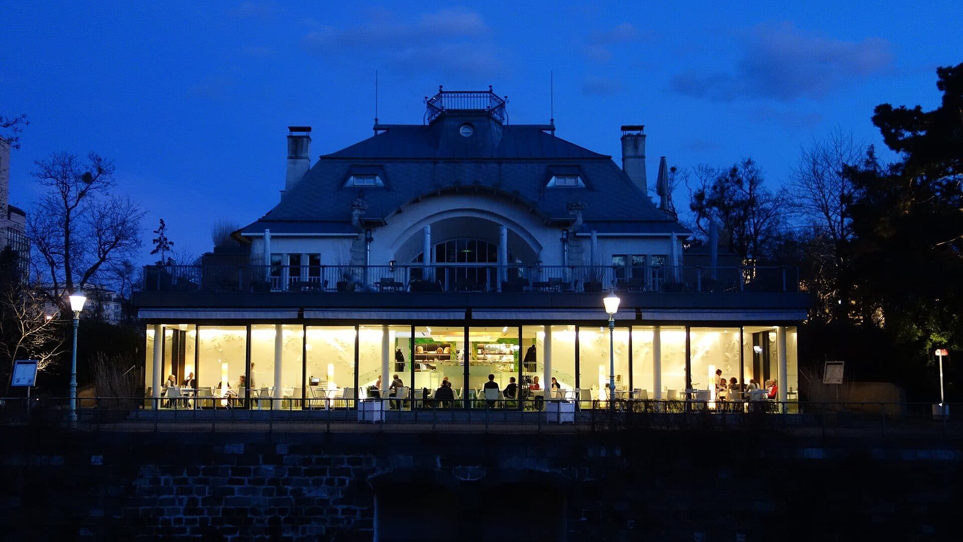 Das Steirereck im Stadtpark am Abend, die Fensterfront ist hell erleuchtet